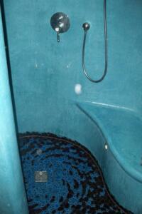 Tadelaktdusche mit Mosaikboden und Sitzbank